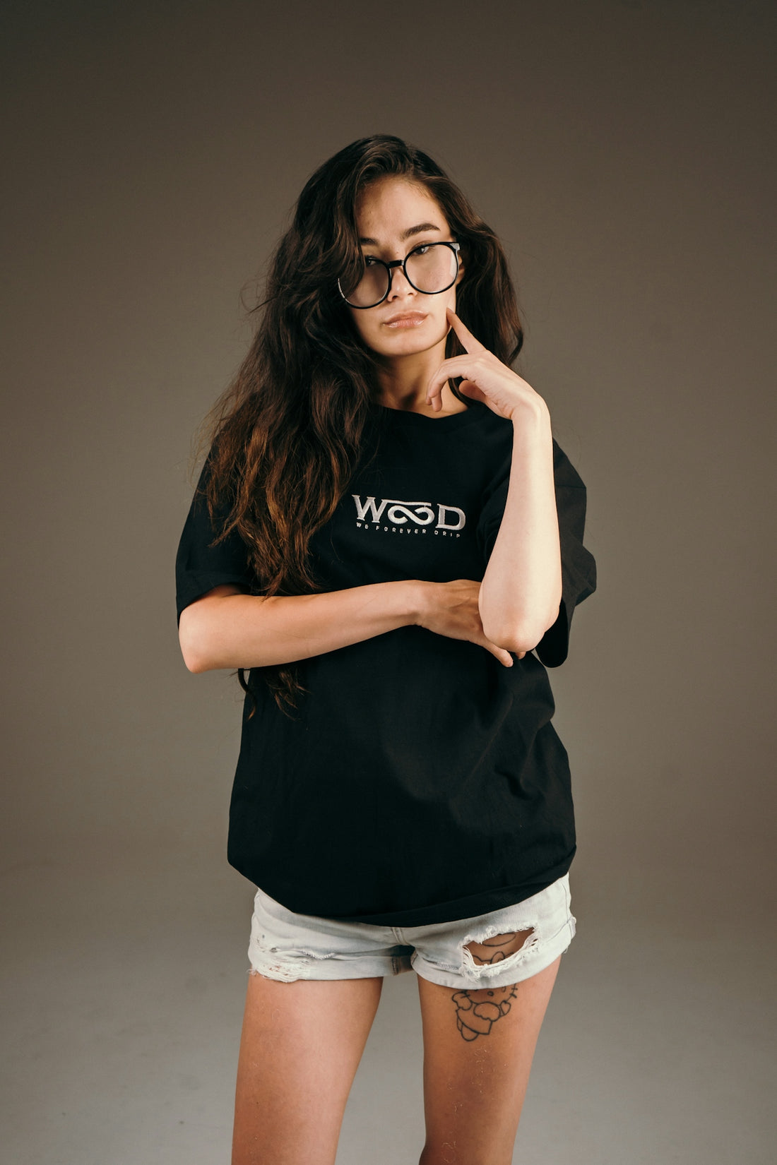 Young woman with glasses and black t-shirt posing