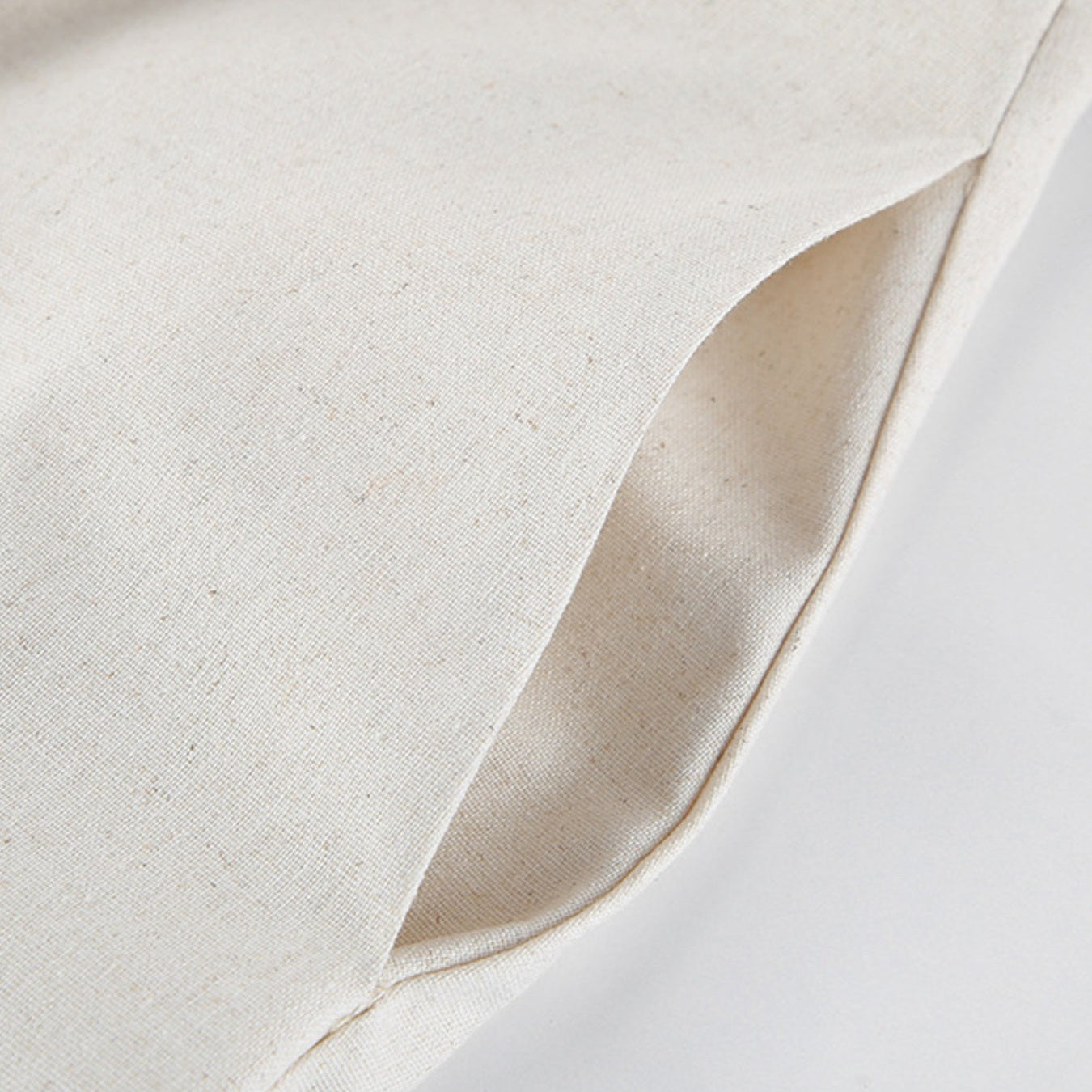 Close-up of beige fabric with a subtle texture on a light background