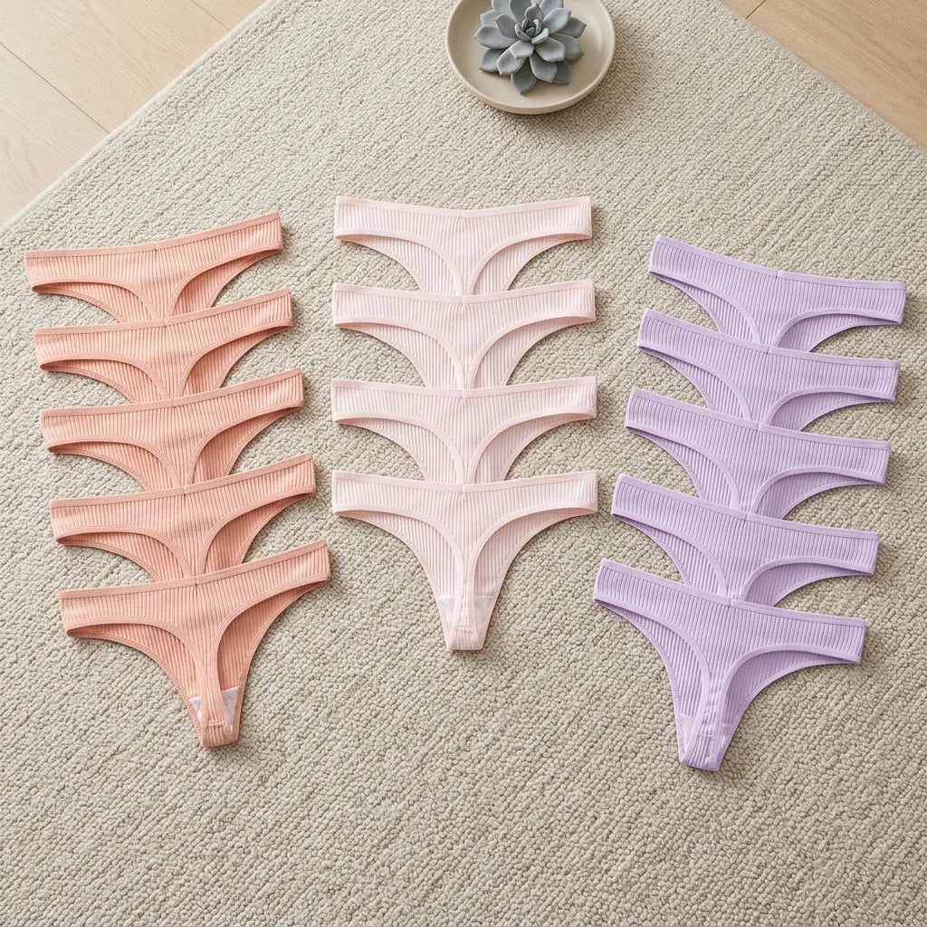 Set of pink and purple women's underwear on a textured surface.