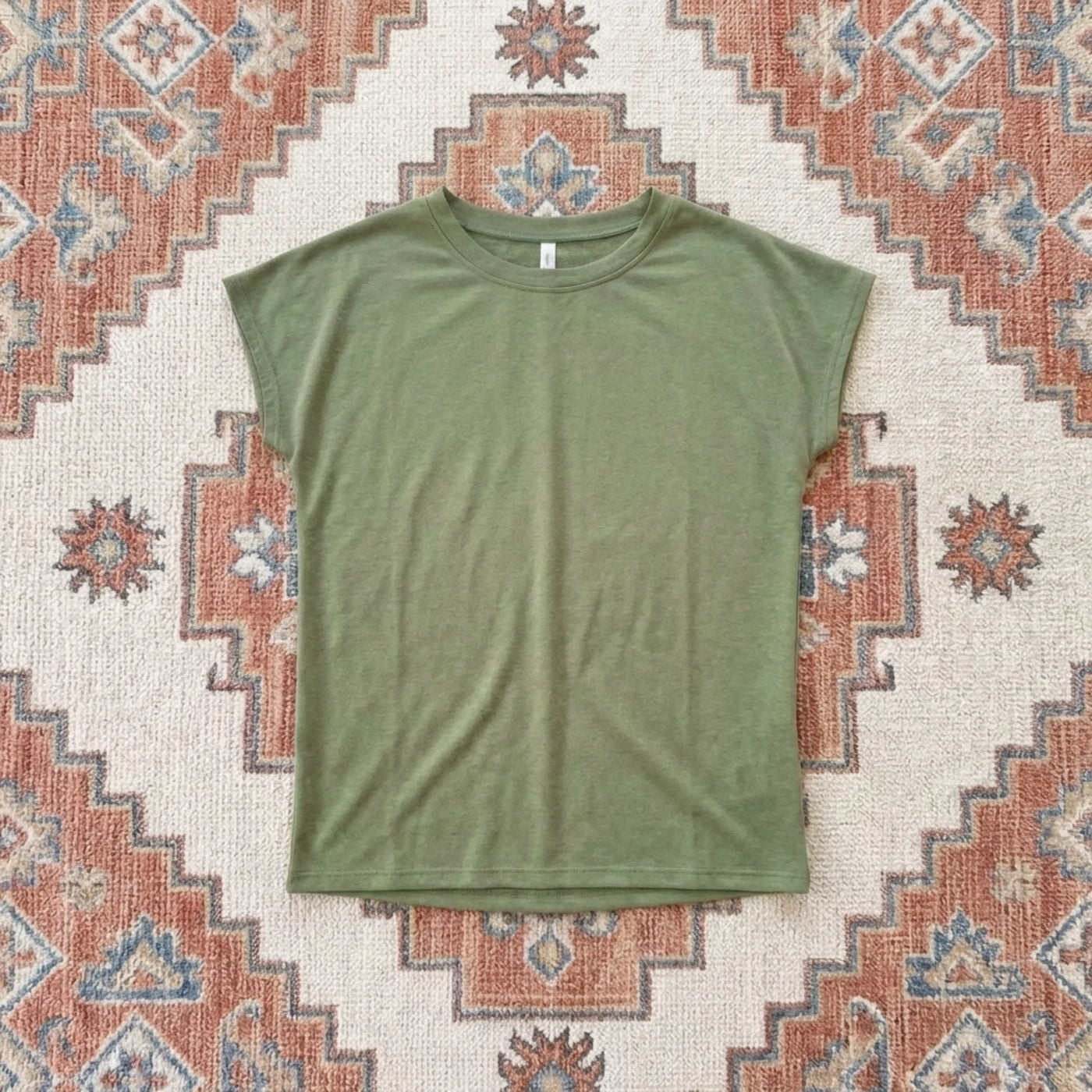 Green t-shirt on a patterned rug