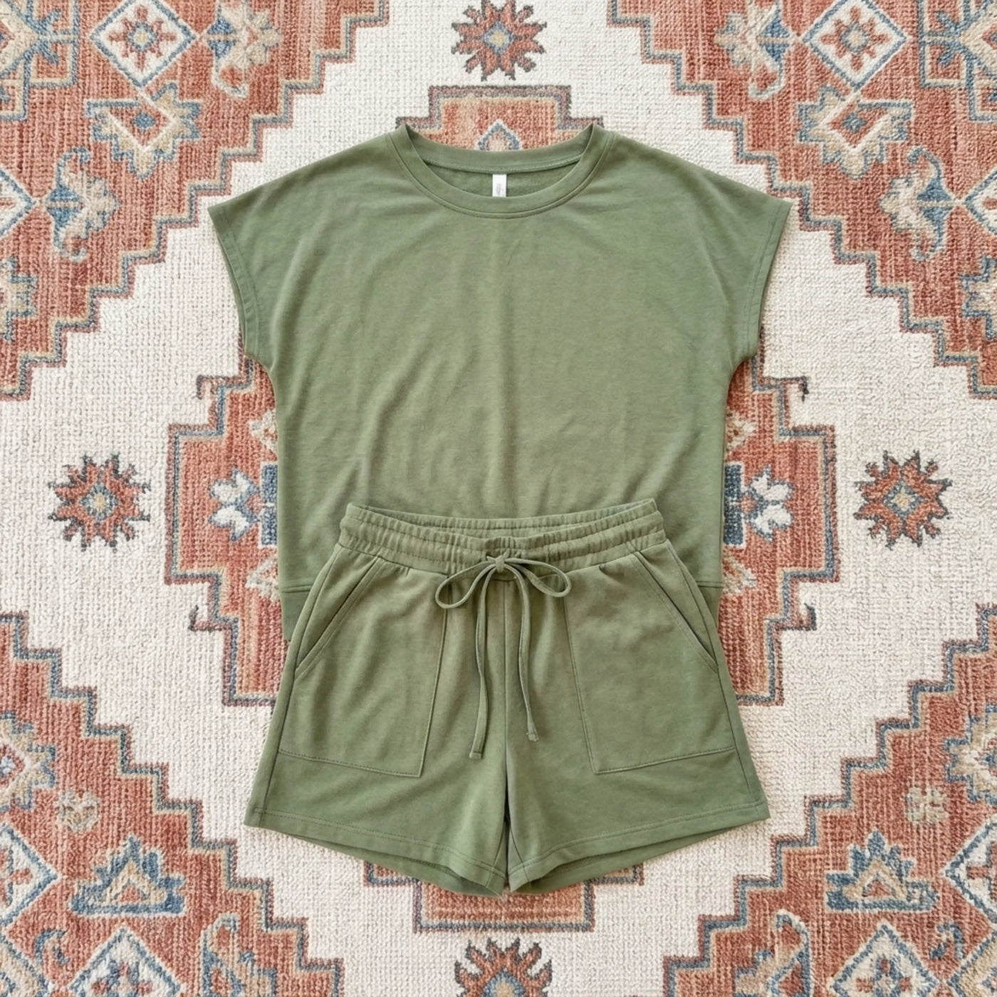 Green sleeveless top and shorts set on a patterned rug